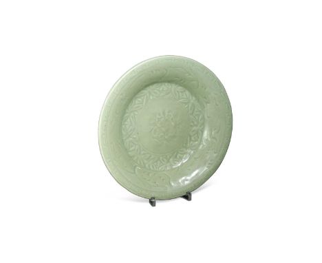 A Chinese Longquan celadon-glazed dish, Ming Dynasty, 15th/16th century, of subtle jade colour, the central carved flower wit