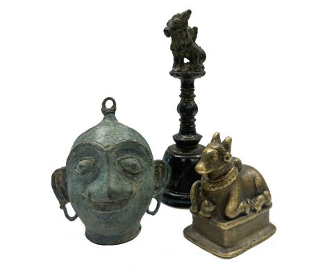 An Indian bronze small temple bell, probably 18th century, surmounted by a Nandi Bull, 16cm high; together with an Indian bra