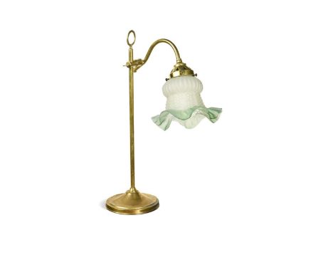 A brass swan-neck reading lamp, early 20th century, the frosted glass shade with height and angle-adjustable arm, raised on a