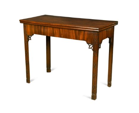 A George III mahogany card table, the rectangular folding top raised on blind fret carved legs decorated with Gothic tracery,