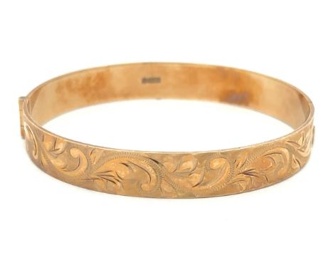 A 9ct gold foliate engraved hinged bangle. Hallmarks for Birmingham. Weight approx 19.13gPlease see sale description/informat
