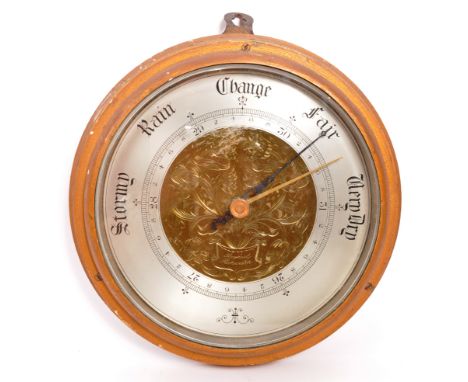 A late 19th Century Victorian wall hanging aneroid barometer of circular form having engraved floral brass centre and painted