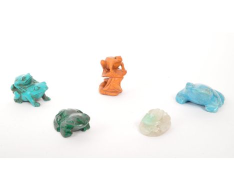 A collection of five carved Netsuke Japanese frog / toad figures comprising of a wooden frog on lilypad, blue resin with thre