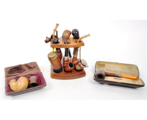 A collection of 20th Century vintage smoking pipes to include two in cases and a wooden pipe holder. Some manufacturers stamp