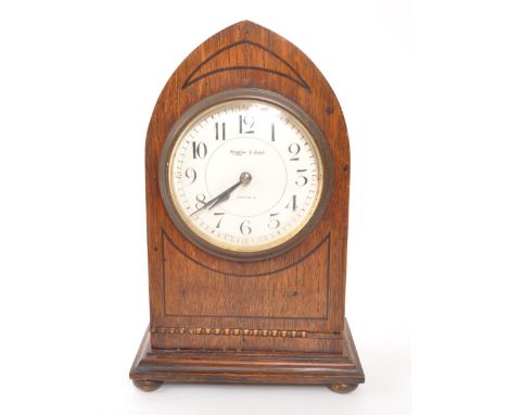 Mappin &amp; Webb - A mid Century circa 1950s oak Mappin &amp; Webb mantel clock having a three pointed arch shape with reede