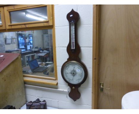 A mahogany wheel barometer with white ceramic dial  