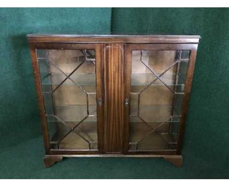 A glazed door bookcase on bracket feet 