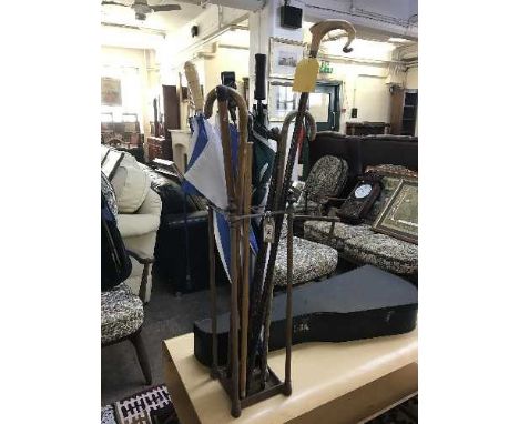 A copper stick stand, walking stick and umbrellas 