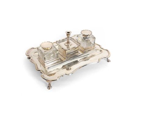 A silver desk stand, By Atkin Brothers, Sheffield 1927, with a central detachable chamberstick flanked by two clear glass ink