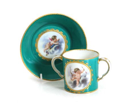 A Sèvres cup and saucer, 18th century, with painted reserves of cupid to an emerald green ground heightened in gilt, interlac