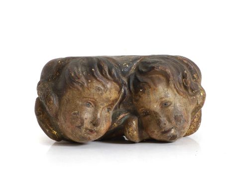 A painted wood cherub head finial, the opposing pairs of cherub heads surrounded by gilded feathers, 21cm wide13.5cm deep11cm