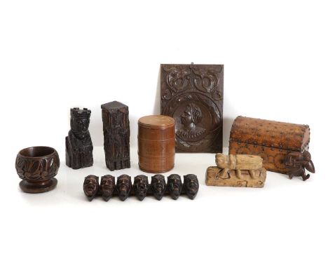 A collection of wooden carved panels,  including a carved wooden grasshopper, an oak carved depiction of a king, a column car