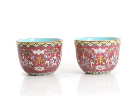 A pair of Chinese famille rose cups, 20th century, of cylindrical form, painted with bats and shou characters among scrolling