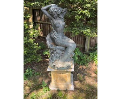 A bronze of a mermaid, 20th century, modelled seated on a scallop shell, with multiple fish, on a reconstituted stone plinth,