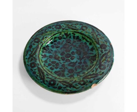 A Persian turquoise-glazed pottery dish, probably 18th century, the dish supported by a short foot, with a white slip and pai