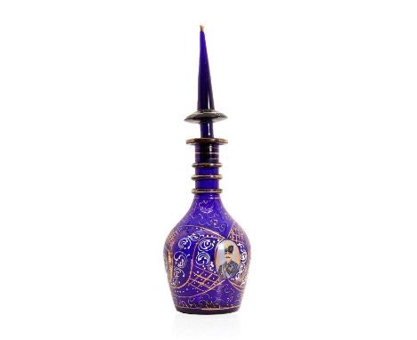 A Bohemian glass decanter, 20th century, the blue glass body with enamel portrait reserve, having a triple ring neck and pend