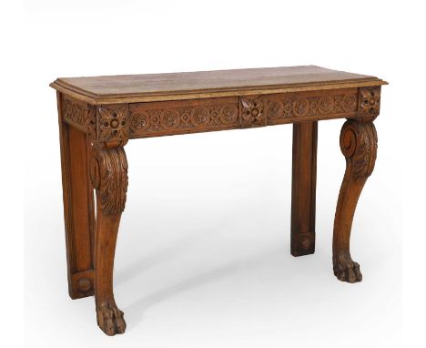 An oak console table, with a moulded top, over a carved frieze with two drawers, on scrolled front supports, 122cm wide 48cm 
