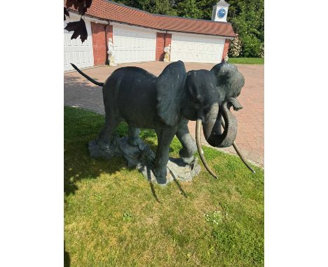 A large bronze elephant, 20th century, with trunk raised and brown green patination,160cm wide88cm deep143cm highCondition Re