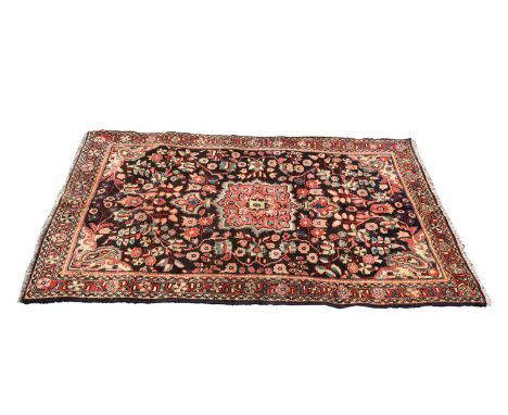 A Mahal wool rug, 20th century, with central medallion to a brown field flanked by scrolling foliage to a multi repeating bor