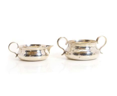 An Edwardian silver cream jug and sugar bowl, by Holland, Aldwinckle &amp; Slater, London 1905, each of squat form with reede