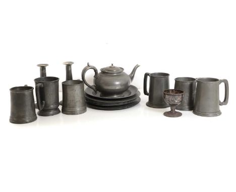 A collection of pewter tableware,  19th century and later, comprising plates, tankards, candlestick holders, and a teapot (qt