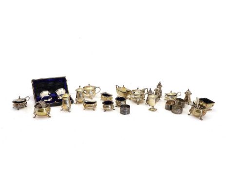 A collection of silver cruet items, comprising three mustard pots, three open salts, four pepperettes, and a three-piece set,
