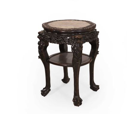 A Chinese hardwood marble-topped urn stand, late 19th century, the inset with a scalloped rouge marble top, the frieze carved