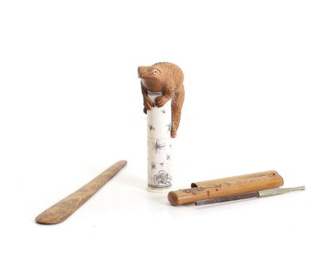 A Japanese boxwood and bone okimono / scroll holder,  the large toad with ivory and glass eyes sat atop of the scroll holder 
