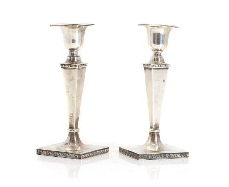 A pair of silver candlesticks, by Walker &amp; Hall, Sheffield 1923, the filled columns of square tapering form with Greek ke