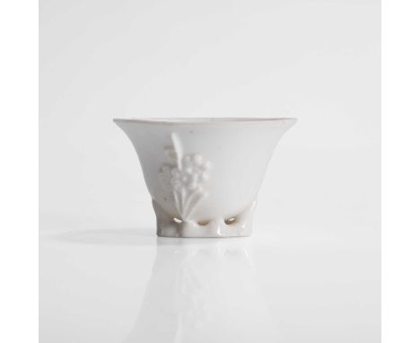 A Chinese blanc de Chine libation cup, Qing dynasty (1644-1911), of rhinoceros form, moulded with a blossoming prunus,6.6cm l