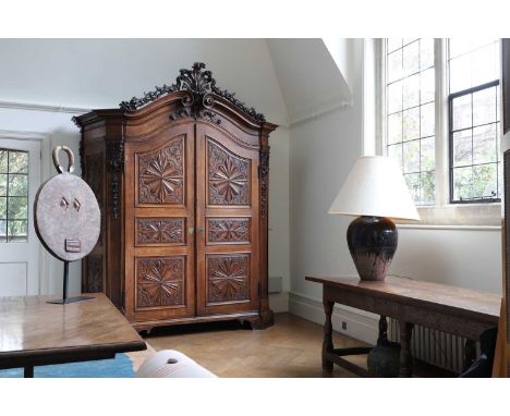 ​​A carved carruba wood armoire, first half of the 18th century, Italian, Genoa, the scrolled pediment over a pair of carved 