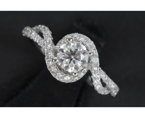 a 0,70 carat high quality brilliant cut diamond set in a ring in white gold (18 carat) with ca 0,50 carat of small high quali