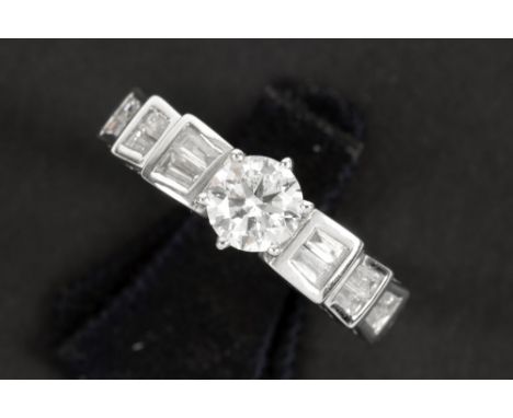 a 0,72 carat brilliant cut diamond set in a ring in white gold (18 carat) with more then 0,40 carat of quality baguette cut d