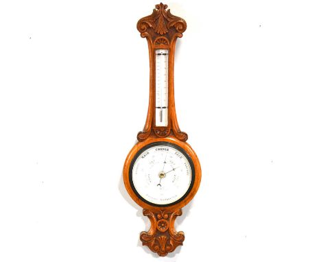 Edwardian carved oak aneroid barometer with thermometer, 86cm.