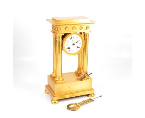 French gilt metal portico clock, rosette frieze, bun feet, repainted circular dial, cylinder movement striking on a bell, 35c