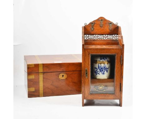 An oak smokers cabinet with ceramic tobacco jar, drawer to base, pierced metal work to top and brackets for three pipes, pipe