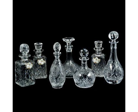 Seven cut glass decanters, all with stoppers, three with ceramic labels, the tallest 33cm.Qty: 7