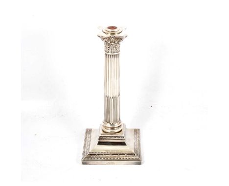 A Corinthian column style silver candlestick, Goldsmith and Silversmith Co. Ltd, London 1906, swag and indented square border