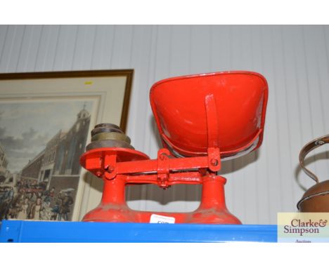 A set of red painted kitchen scales and weights
