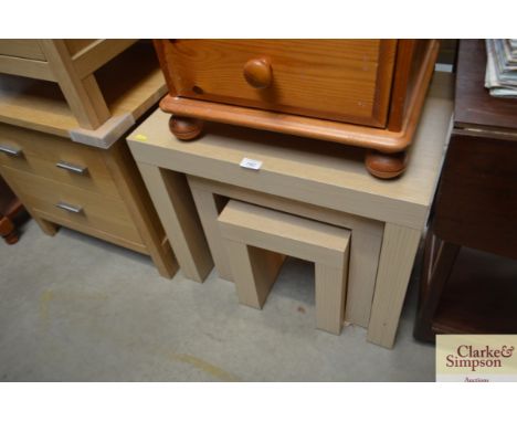A light oak effect nest of three occasional tables 