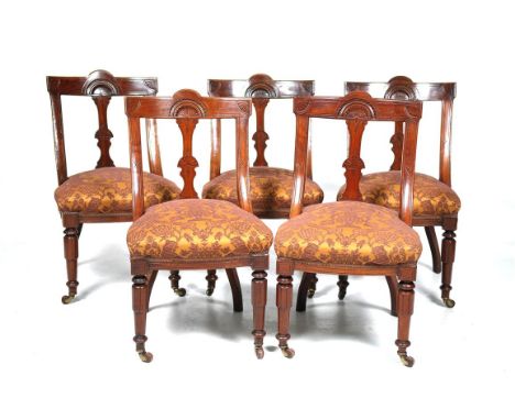 A large set of ten Victorian walnut carved spoon back dining chairs
Each with a shaped rectangular cresting centred with a le