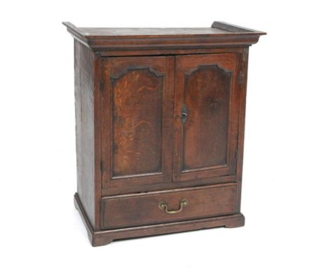 An 18th Century oak spice cupboard
With a cavetto cornice above a pair of panelled cupboard doors enclosing five short drawer