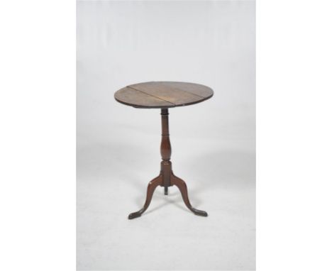 An early 19th Century oak lamp table
The 60cm diameter three plank hinged top raised upon a baluster collared shaft and trifo