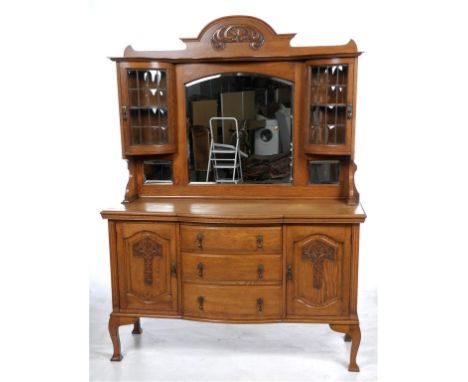 A late 19th early 20th Century oak mirror back bowfront sideboard
With an arched top carved with scrolling leaves above a ser