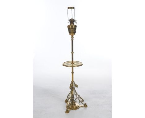 A choice Victorian brass standard lamp
With an ogee shaped brass reservoir, single adjustable burner enclosed within a leaf a