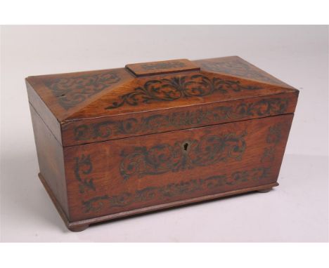 A 19th Century rosewood and brass inlaid sarcophagus tea caddy
The hinged top finely inlaid with brass foliage with a red vel