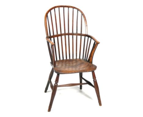 An early 19th Century comb back Windsor chair
With an arched rail above plain spindles, shaped outswept arms supports, dished