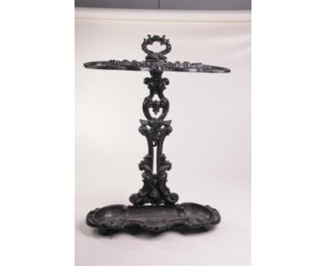 A cast iron stick stand
With a leafy scroll handle, outswept curvilinear stick apertures with a shaped leafy tray, 66x48cms.