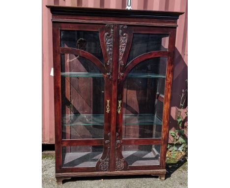 An Art Nouveau mahogany display cabinet having a moulded cornice, two doors with applied floral mouldings, loose glass shelve