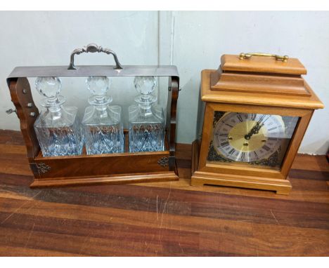 A reproduction three bottle tantalus and mahogany cased mantel clock mantel clockLocation:If there is no condition report sho